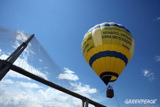 Hot air balloon rises over Manaus in the Amazon, bearing the message 'Stop the c