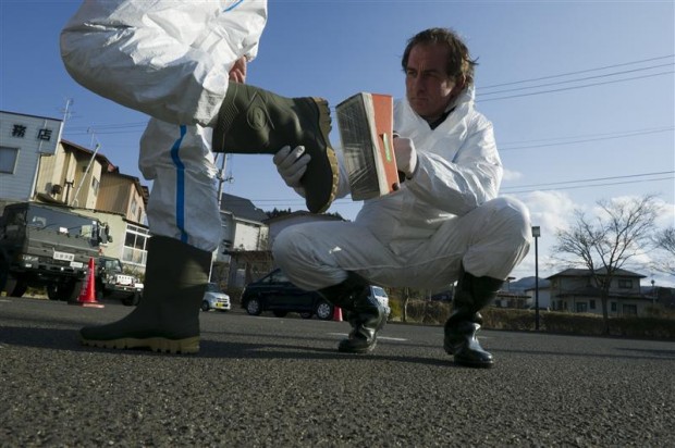 Jacob Namminga checks a colleague's boots for traces of radioactivity