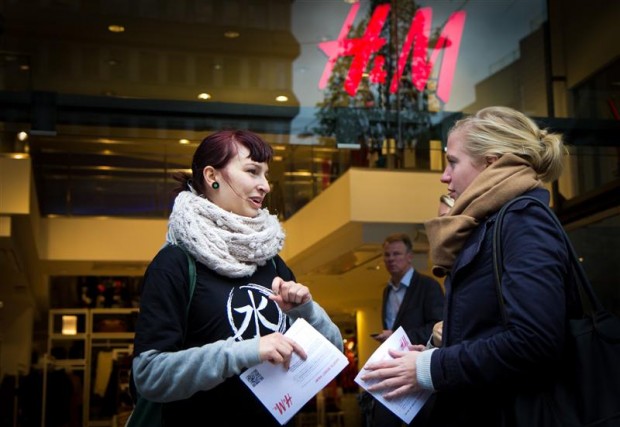 Greenpeace volunteer talks to a passer-by outside H&M in Stockholm