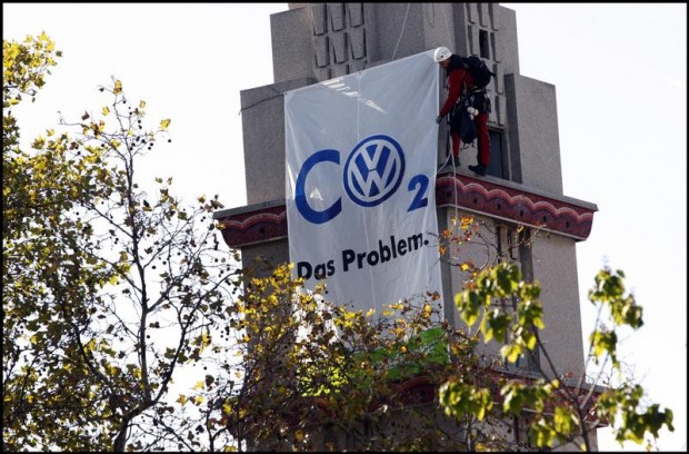 Activists from Greenpeace France hang a banner at the Paris Motorshow