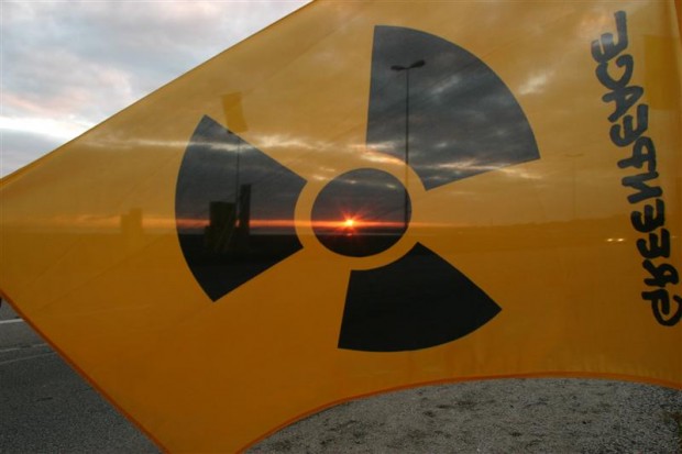 Setting sun shines through nuclear protest flag with radioactive symbol