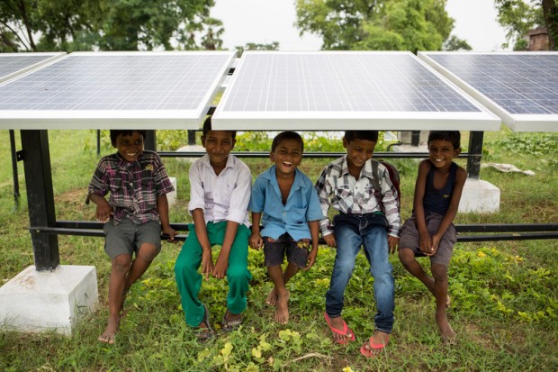 Children in Dharnai Village in IndiaChildren sit under solar panels at Bishunpur