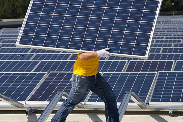 Solar panel being carried by worker