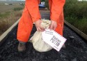 Activist with a bag of coal from the train, with address label to Vladimir Putin
