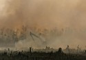 An excavator creates a canal in Riau Province, Indonesia, despite heavy smoke