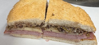 MUFFULATTA "NEW ORLEANS STYLE" HALF HAM, SALAMI, SWISS, ROMANO, PROVOLONE, OLIVE SALAD, ITALIAN DRESSING