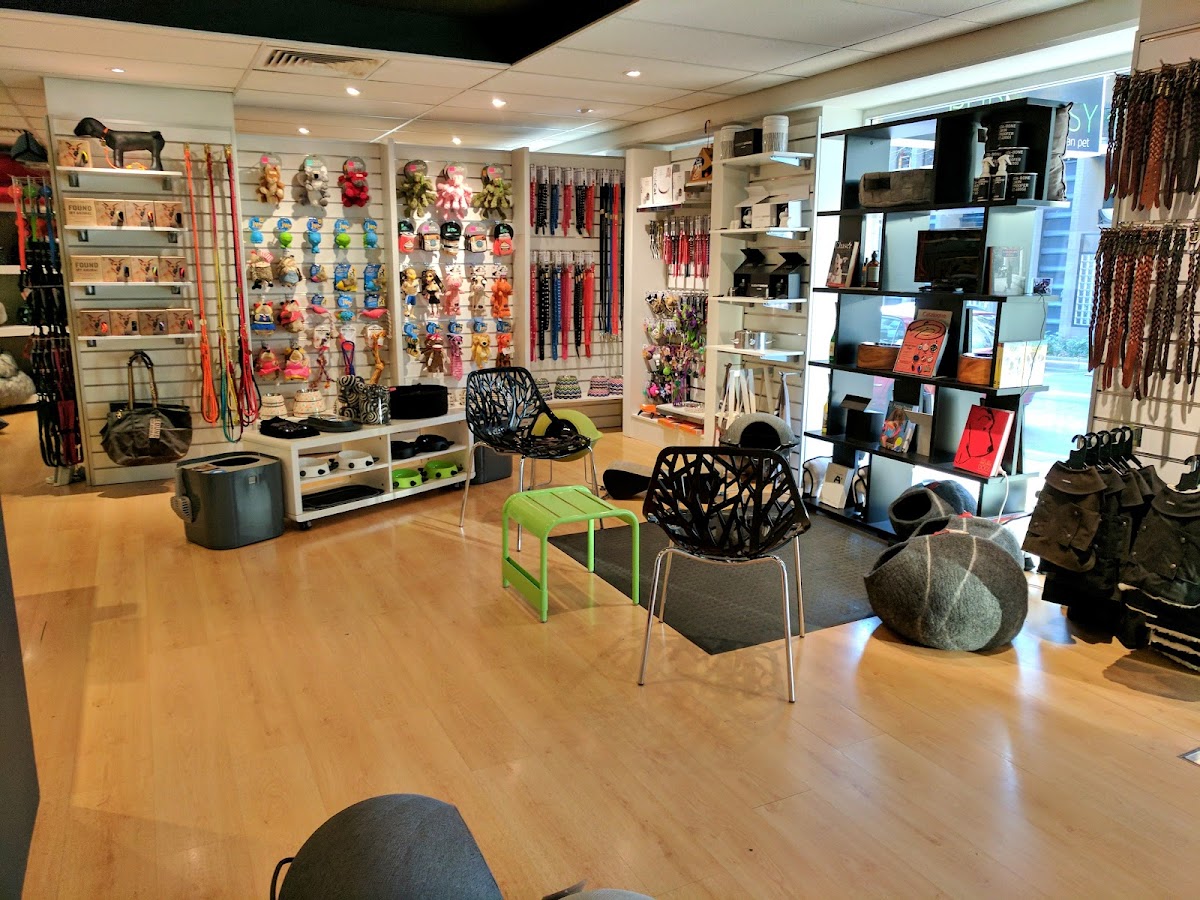 Interior of a pet grooming salon with shelves stocked with products and chairs.