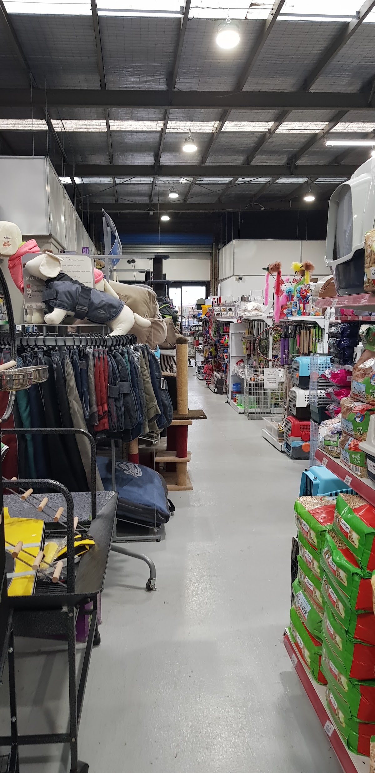 Interior of a pet grooming salon with shelves stocked with products and equipment visible.