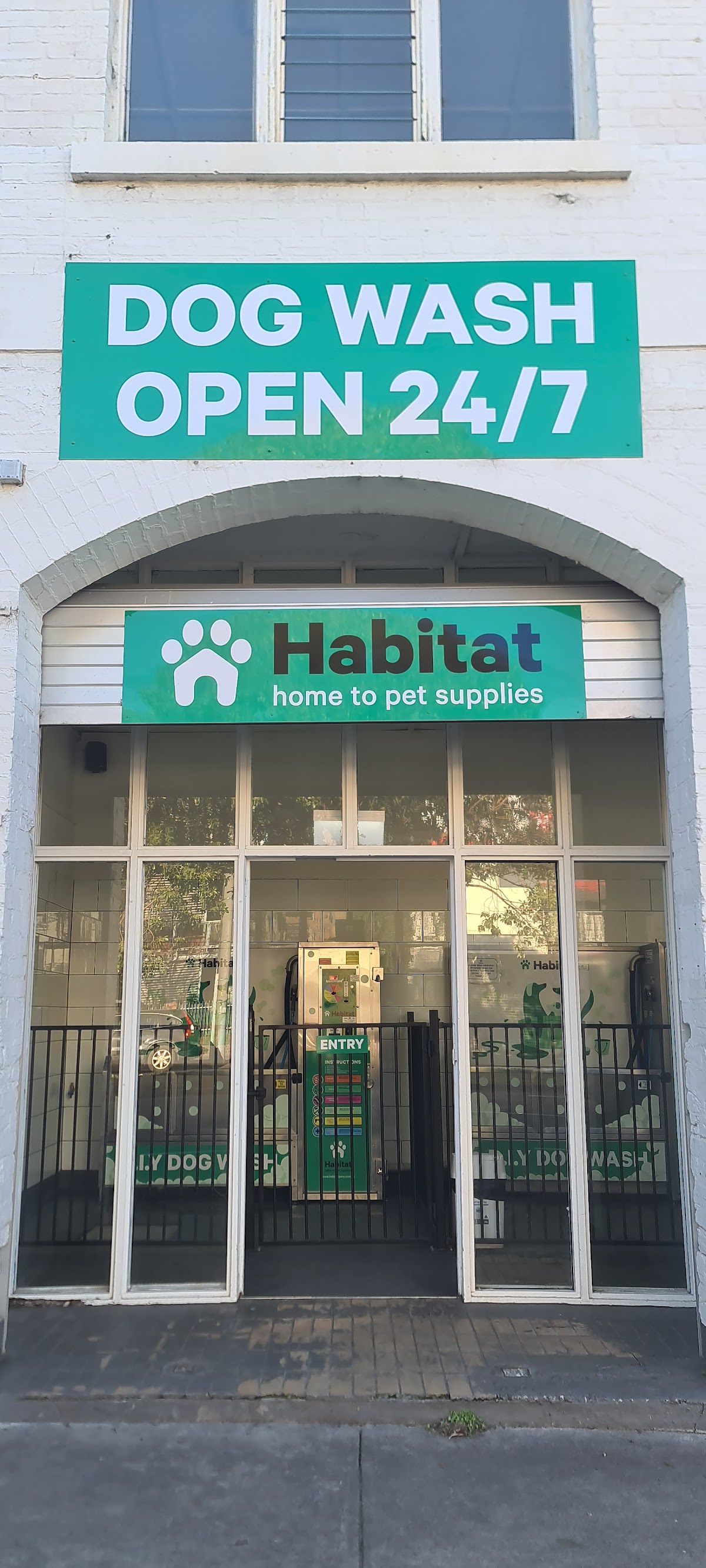 Dog wash storefront with 'Habitat' logo and 'Open 24/7' signage.
