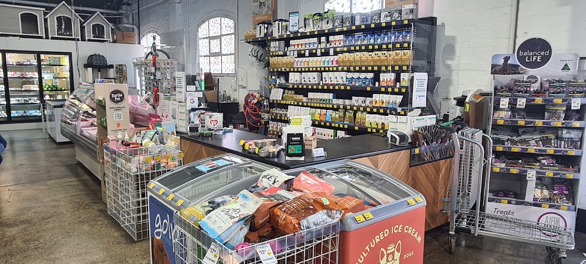 Pet store interior with shelves of dog treats and supplies, including ice cream for dogs.