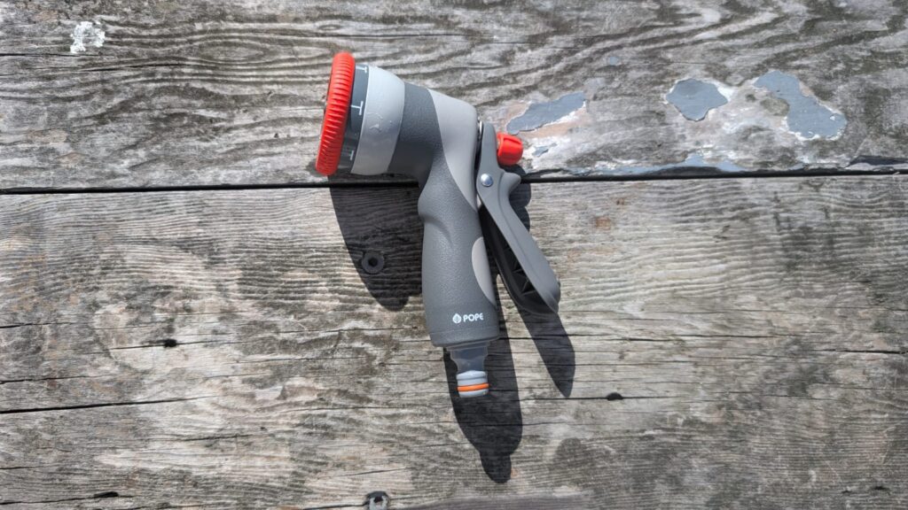Garden hose nozzle on wooden deck.