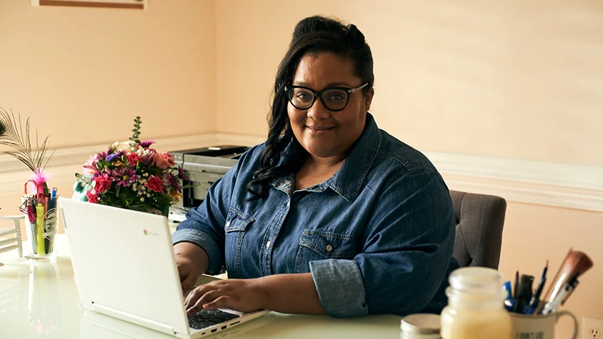 Lady sitting on the desk working on her laptop