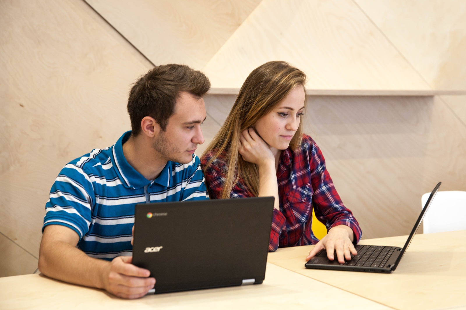 Studenții Google Atelierul Digital mulțumiți în timp ce lucrează la un laptop.