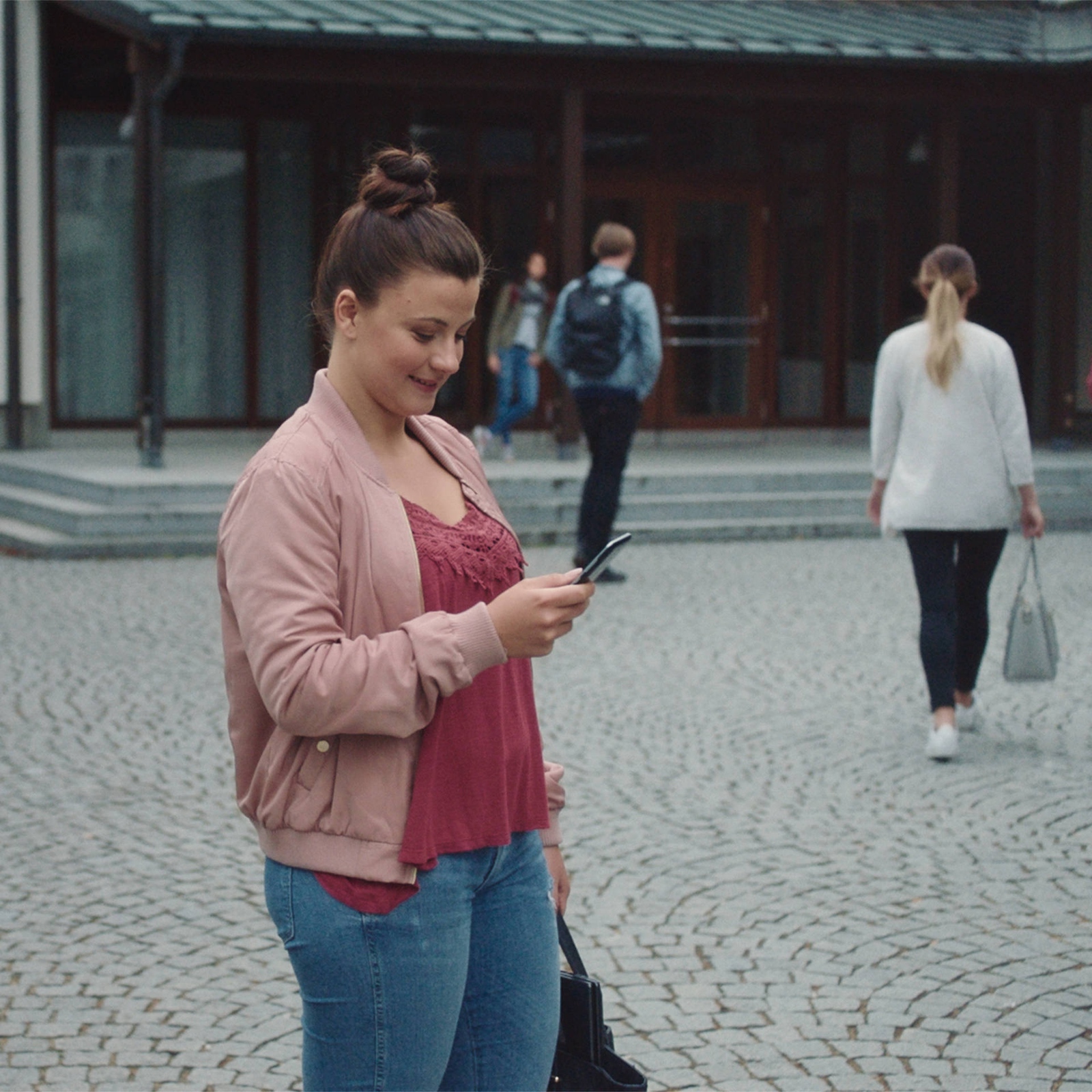 Eine junge Person schaut auf ihr Smartphone.