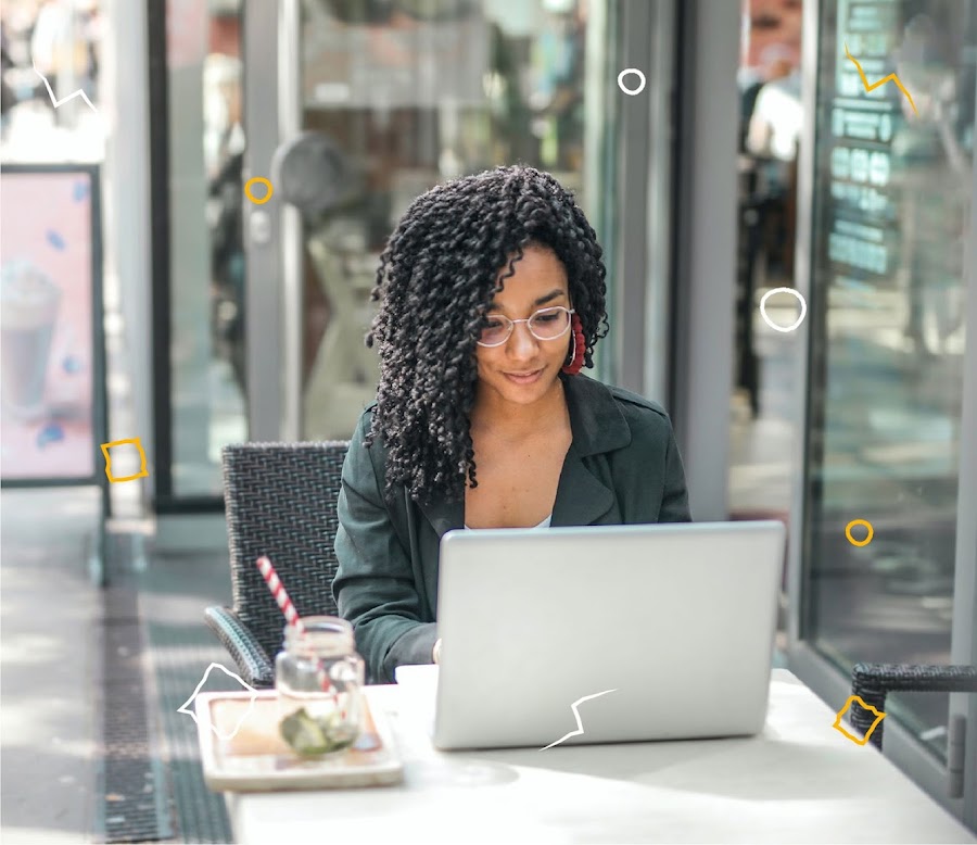 A young woman works on her laptop at a cafe