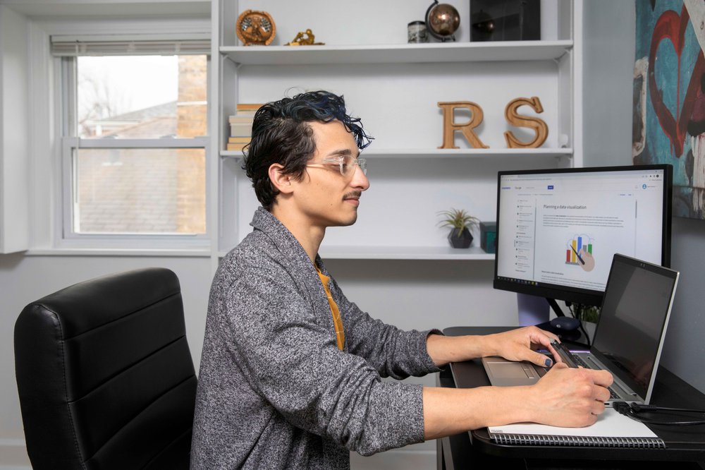 Uno studente di Google career certificates guarda la telecamera mentre lavora sul suo computer