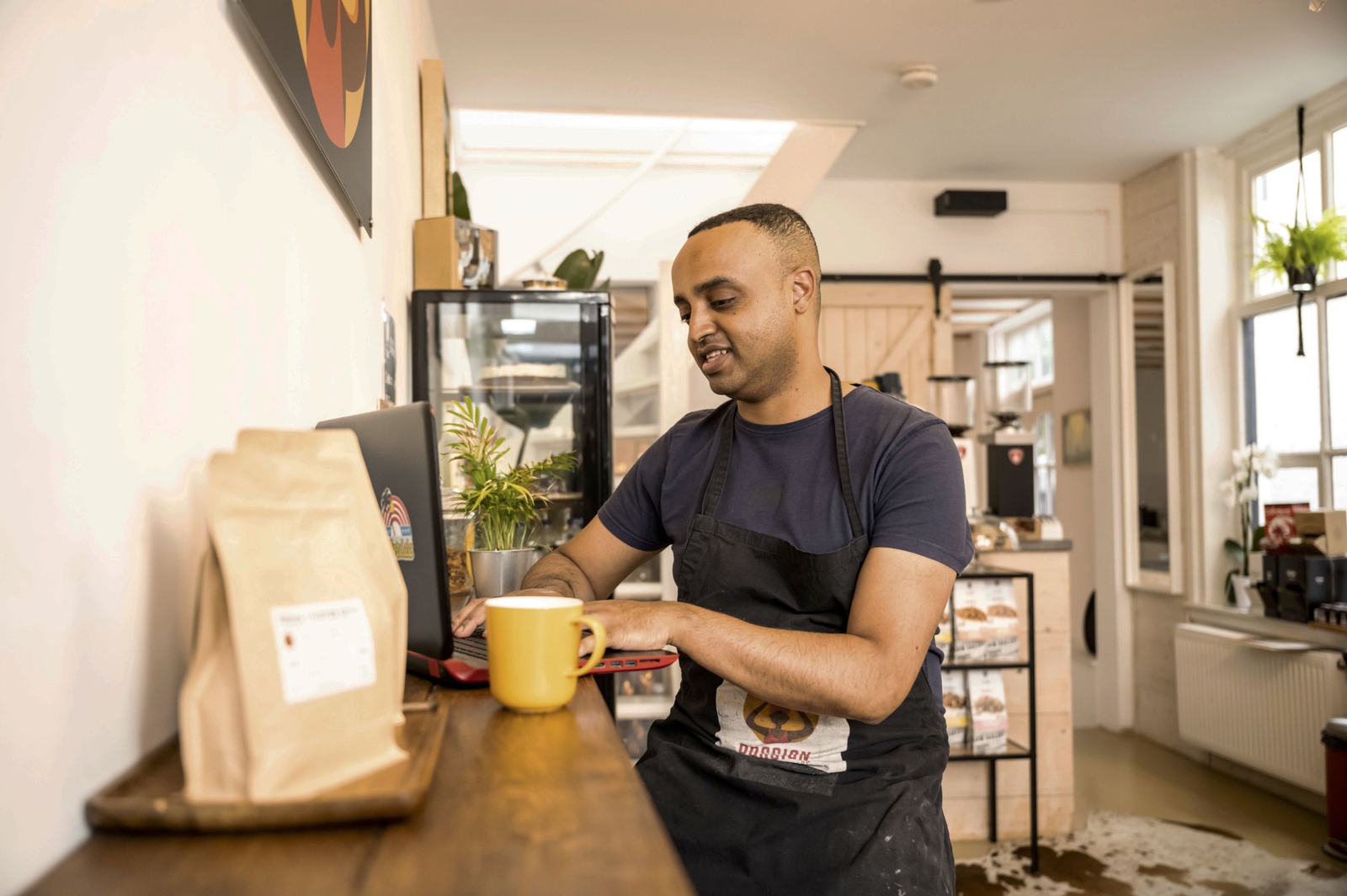 Mand arbejder på sin computer i en kaffebar.