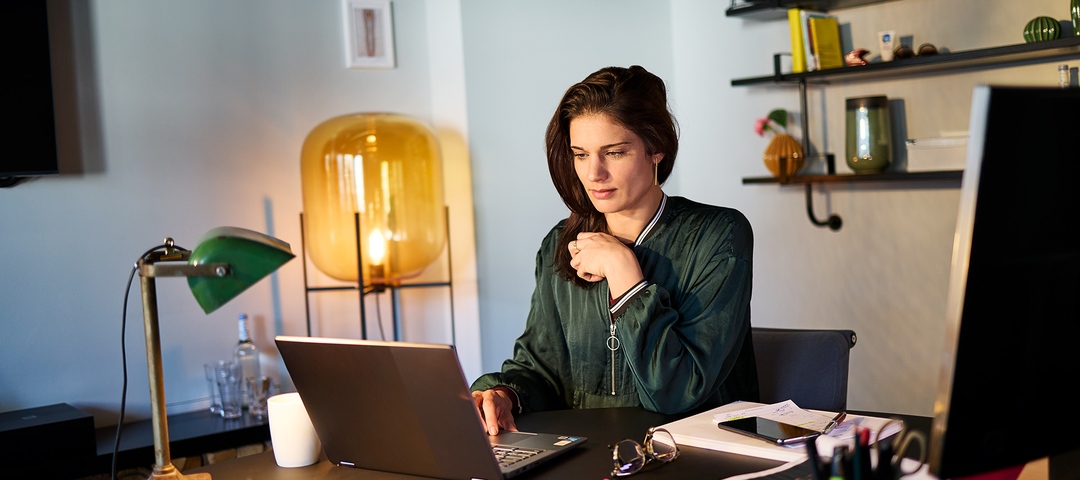 Eine Person, die in einem Büro am Laptop arbeitet.