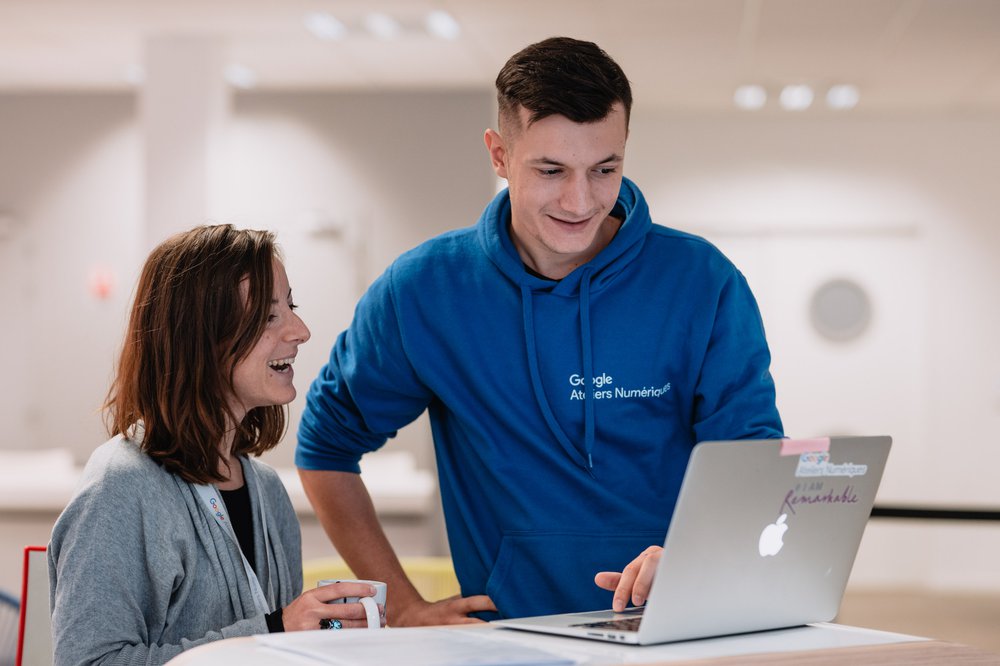 Une apprenante avec un coach Google Ateliers Numériques pendant une formation.