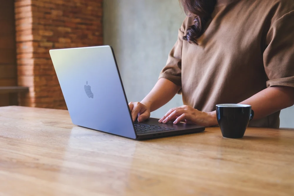 A MacBook Pro at the macOS setup screen asking for an Apple Account password