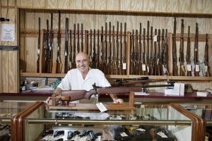Portrait of a happy gun shop owner