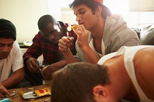 Gang Of Young Men Taking Drugs Indoors