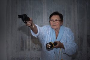 Senior-holding-guns-and-torch-for-home-defense
