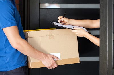 A person signing parcel delivery papers