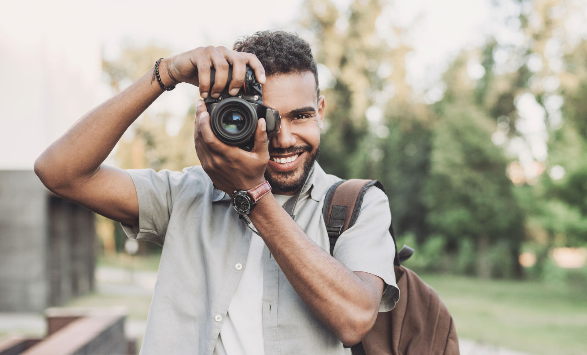 Young man photographer takes photographs with dslr camera in a c Insurance for Photographers