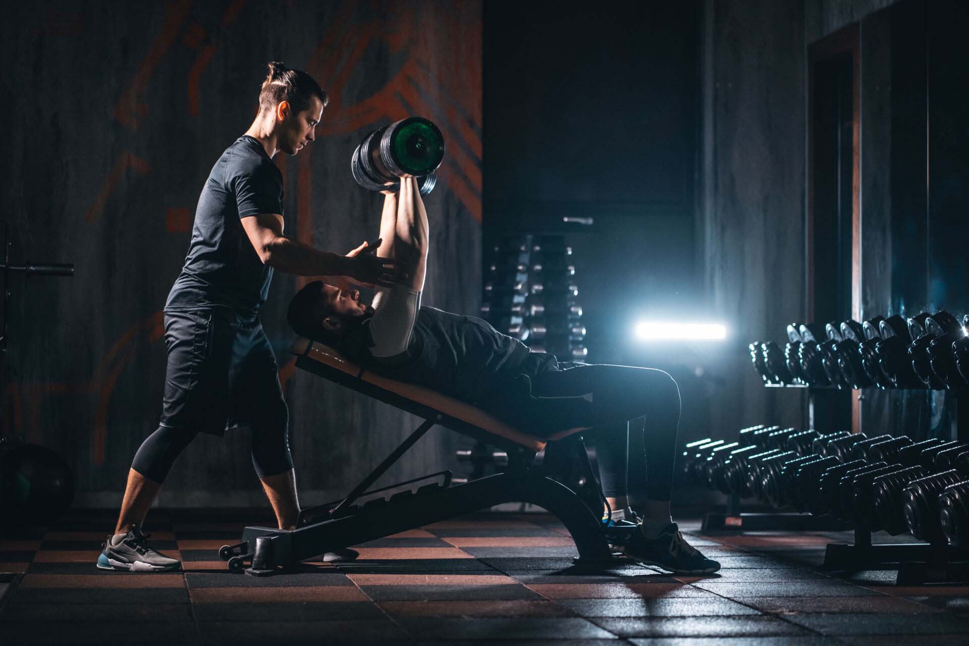young man has workout with personal trainer in modern gym Insurance for Personal Trainers