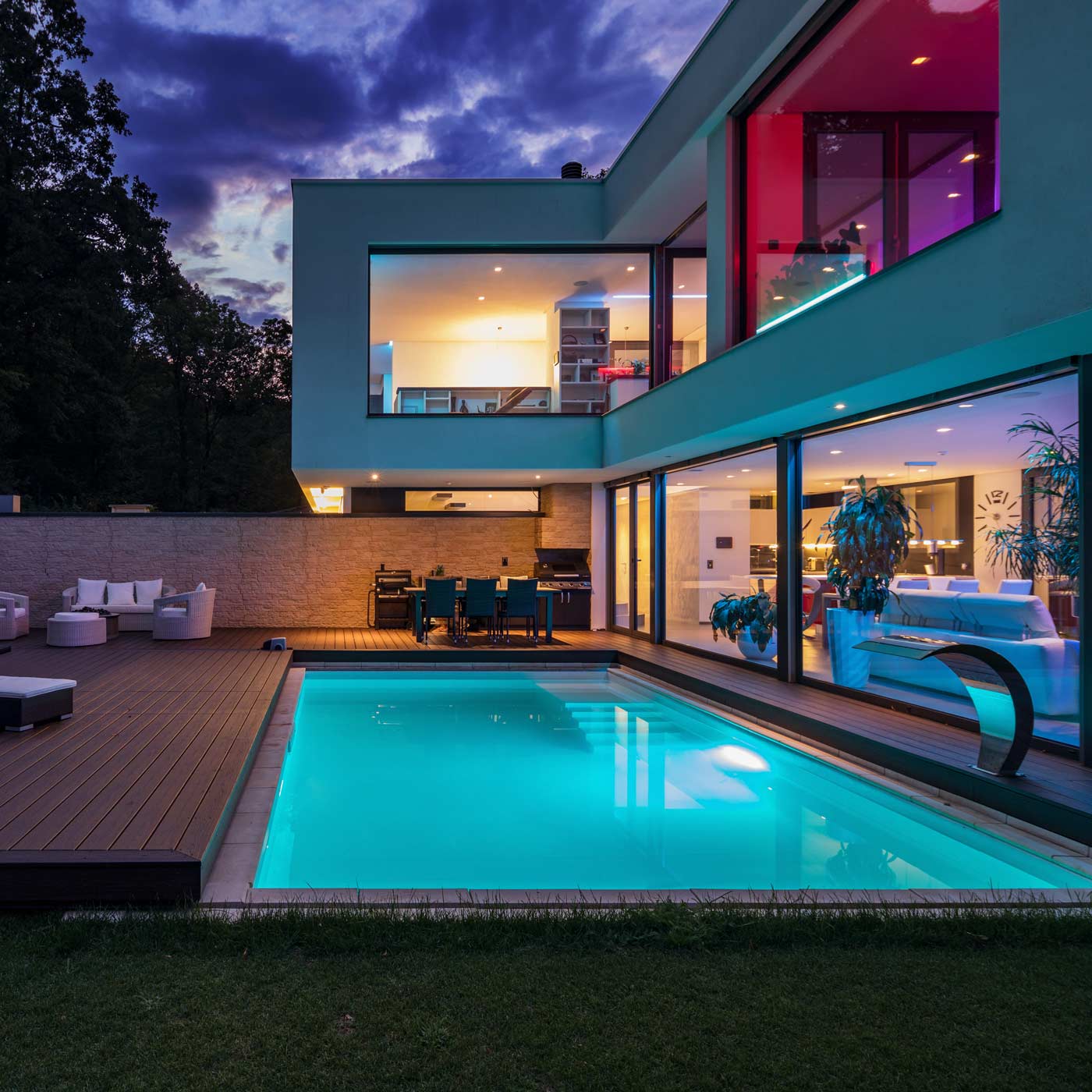 Homeowners insurance. High end home with pool at night with fancy lighting. Homeowners insurance. High end home with pool at night with fancy lighting.