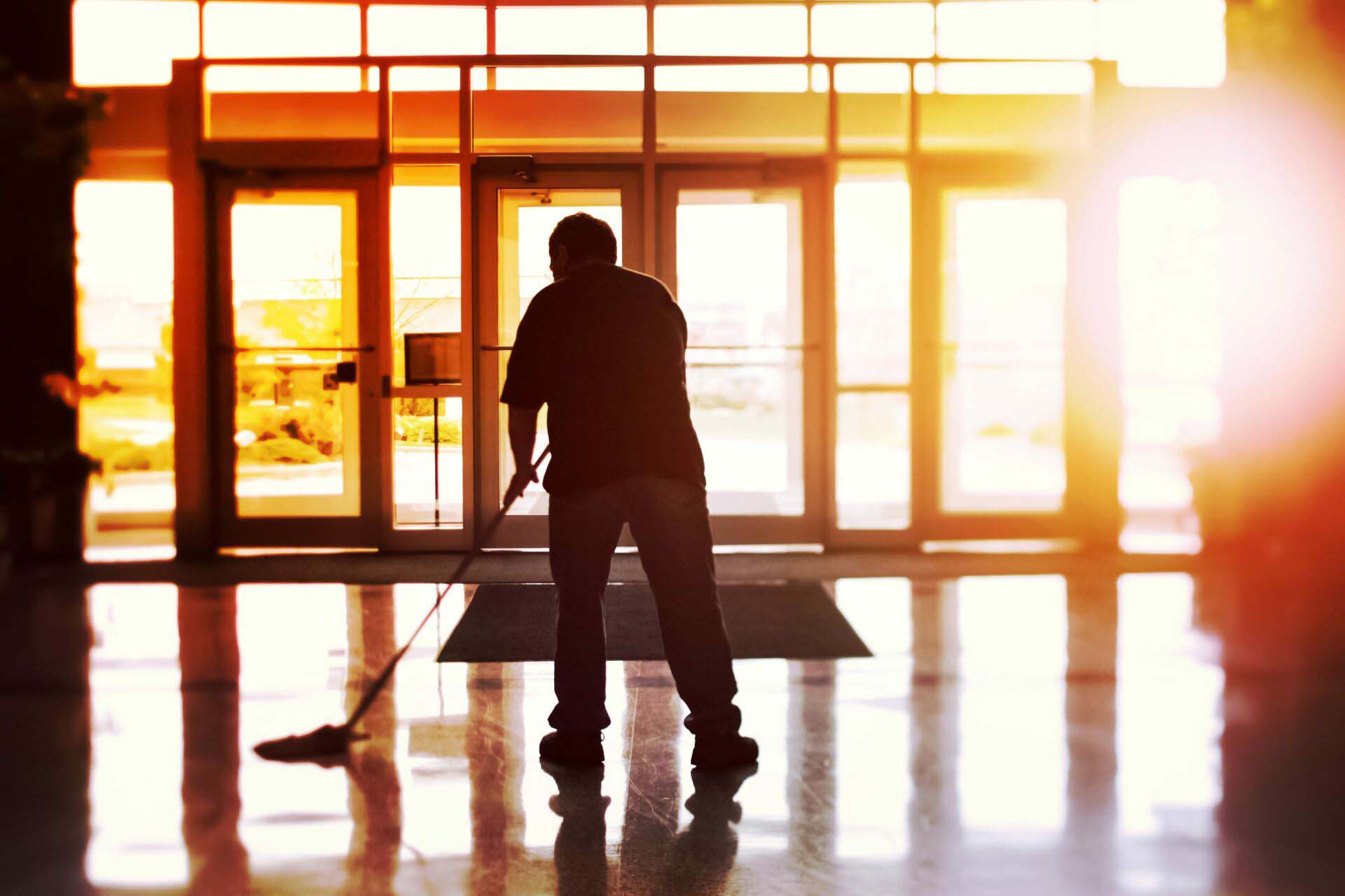 Janitor mopping an office floor, shallow focus, tilt shift image Insurance for Janitorial Services