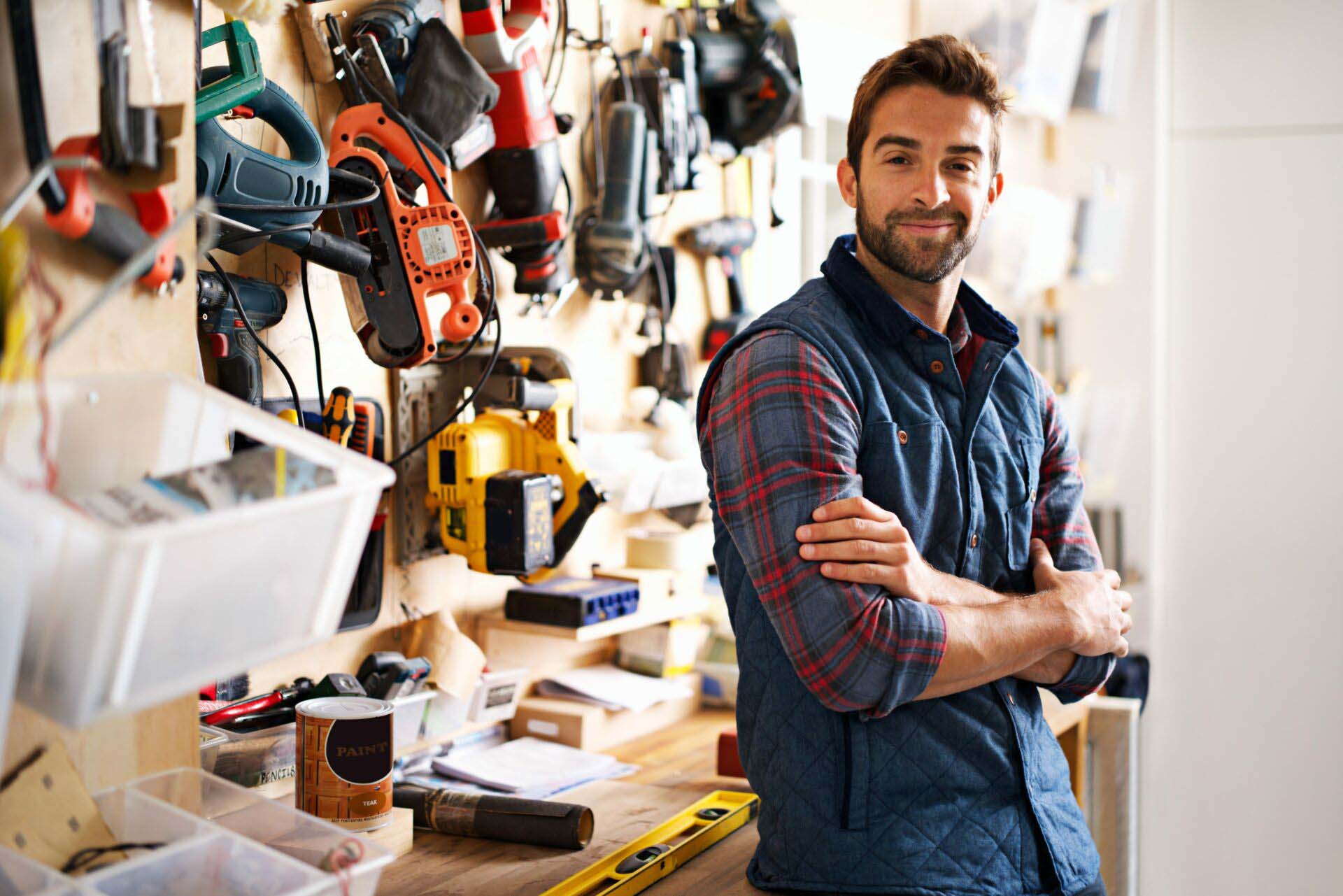 Lets fix it. Portrait of a handsome young handyman standing in front of his work tools. Insurance for Handyman Services