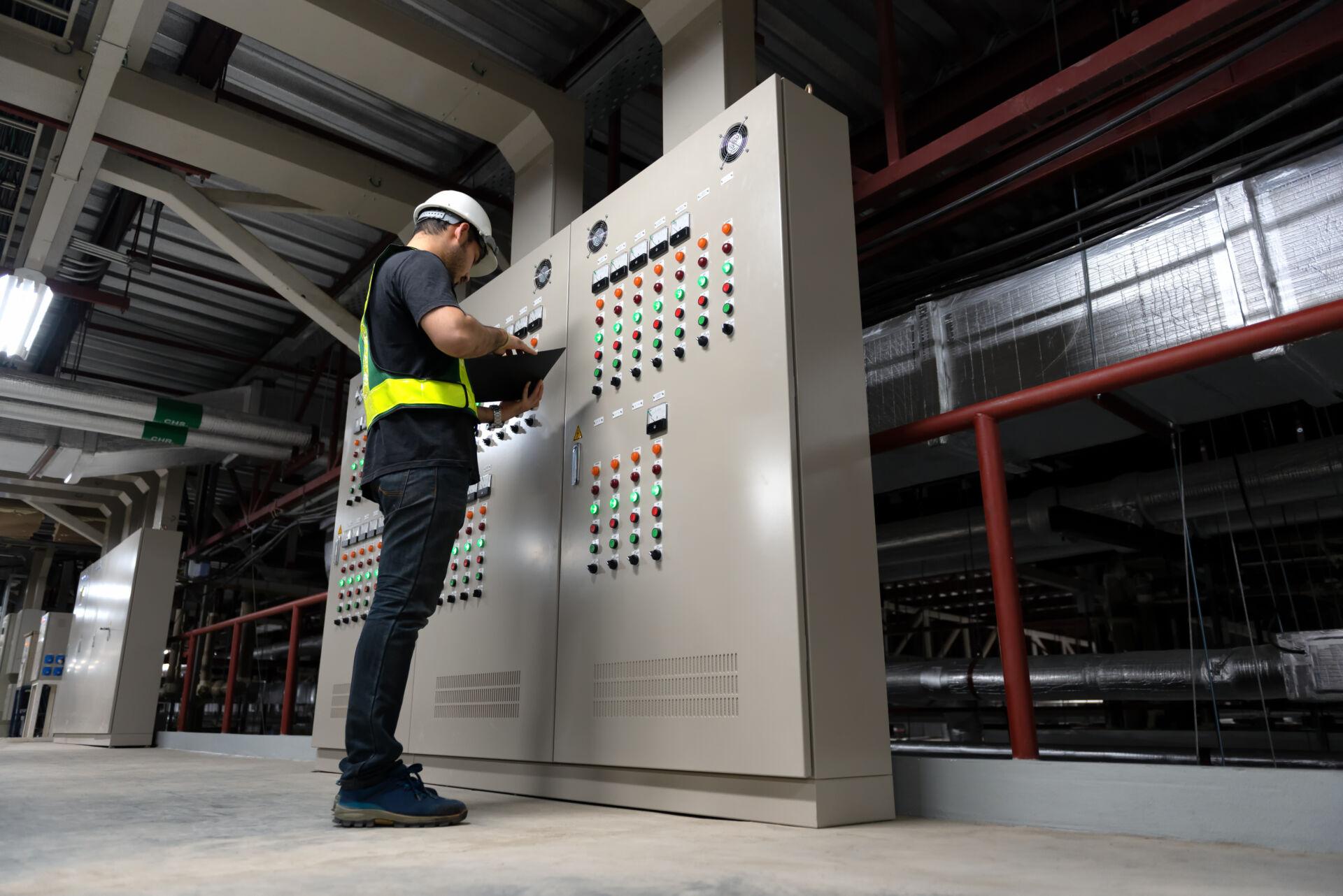 Electrical Engineer team working front HVAC control panels, Technician daily check controls system for security functions in service room at factory. Heating,Ventilation,Air Conditioning. Insurance for Control Systems Integrators