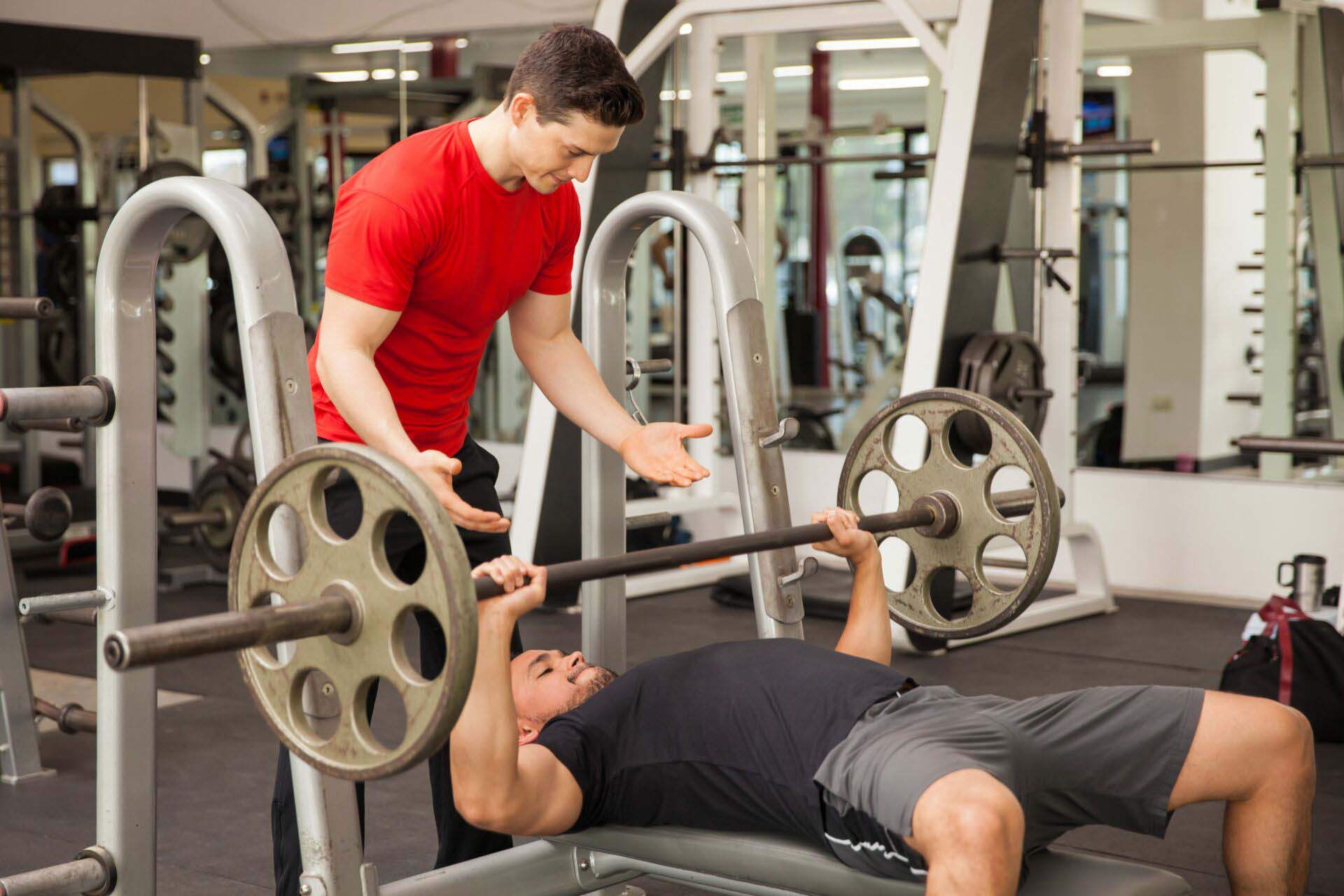 Young man spotting each other in a gym Insurance for Fitness Instructors