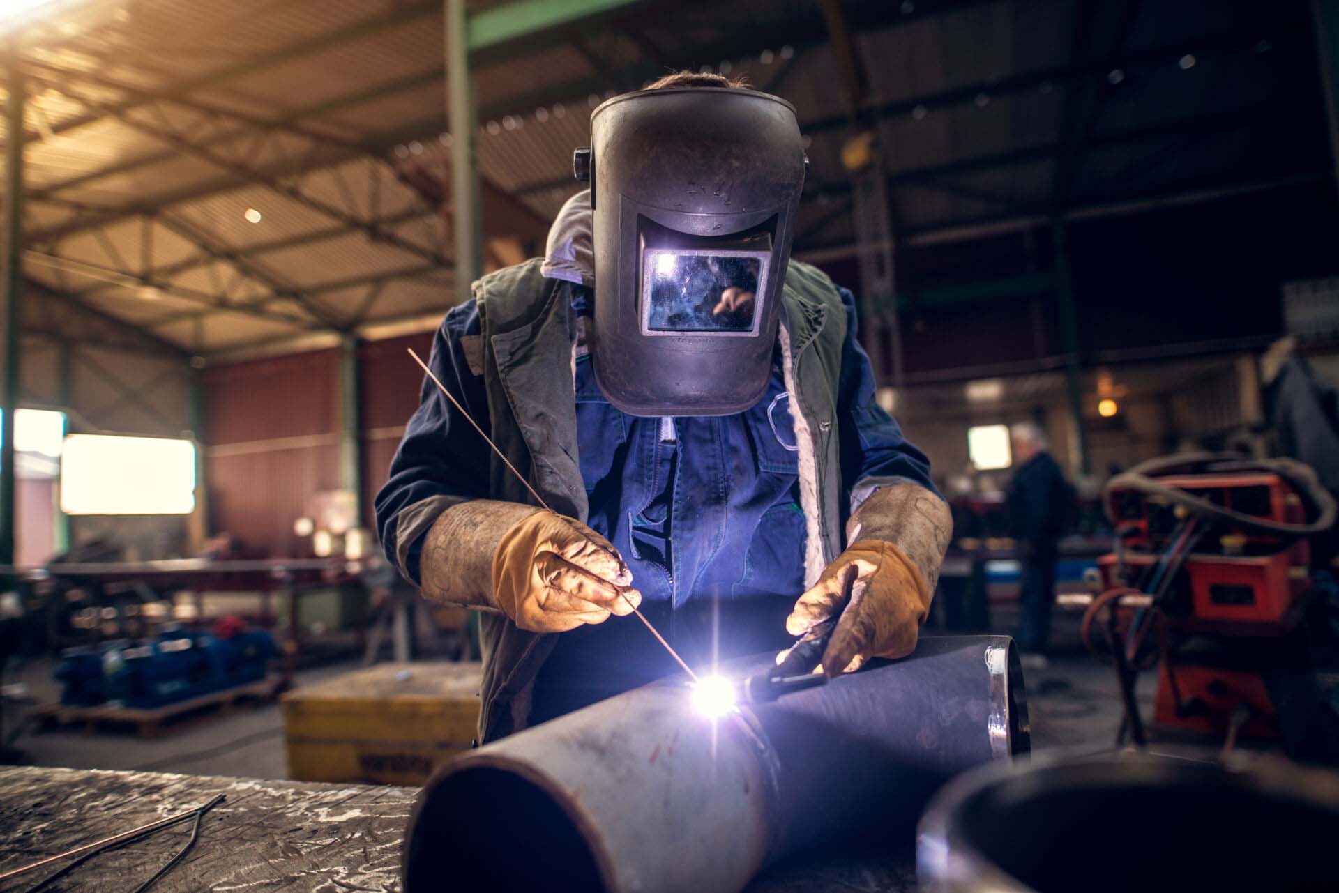 Close up portrait view of professional mask protected welder man Insurance for Welders