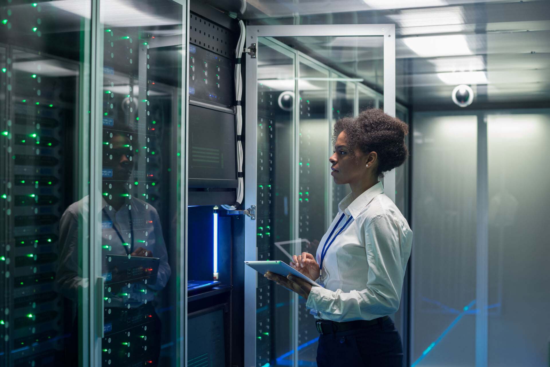 Female technician works on a tablet in a data center Insurance for Web Hosting Providers