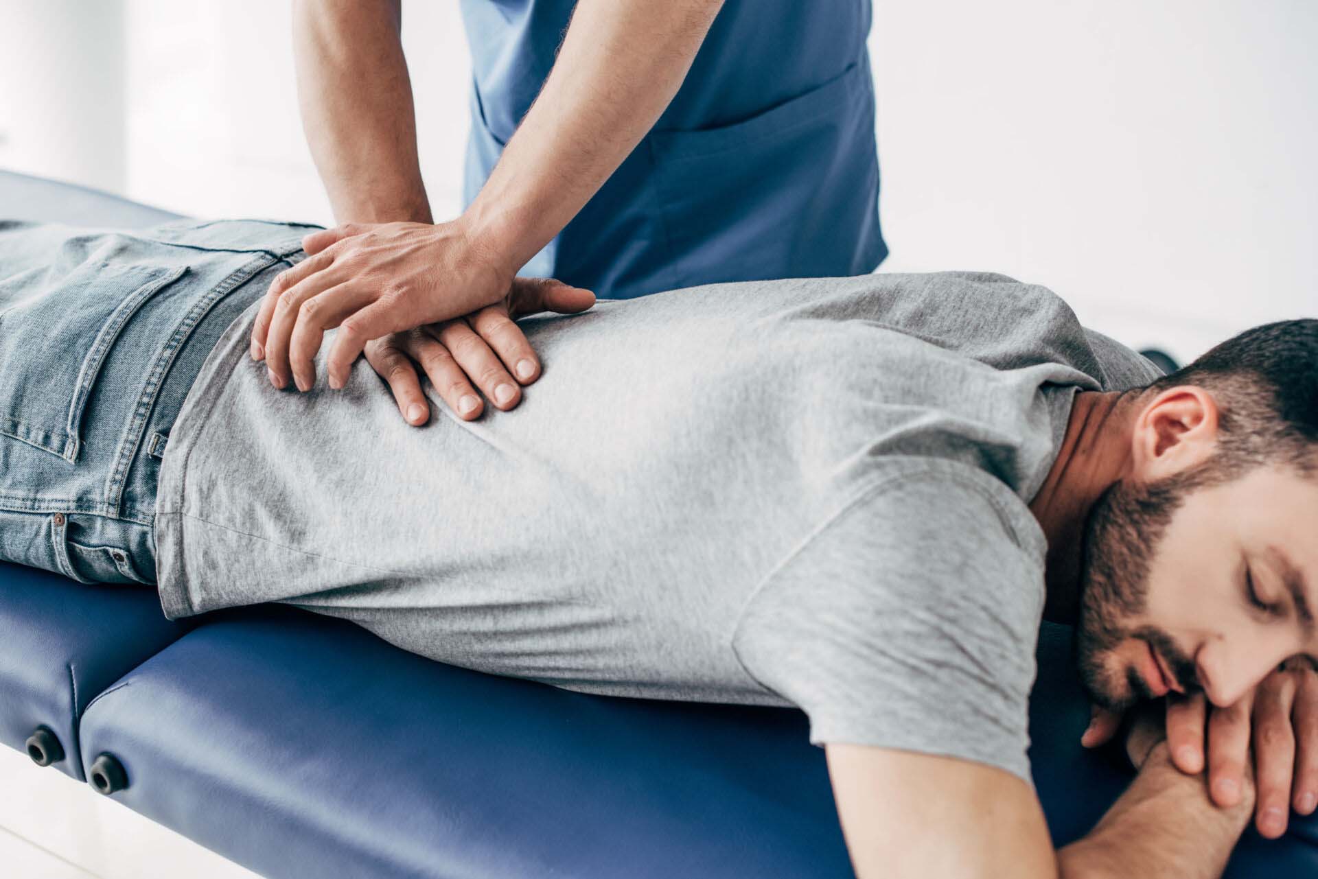 chiropractor massaging back of man on Massage Table in hospital Insurance for Chiropractors