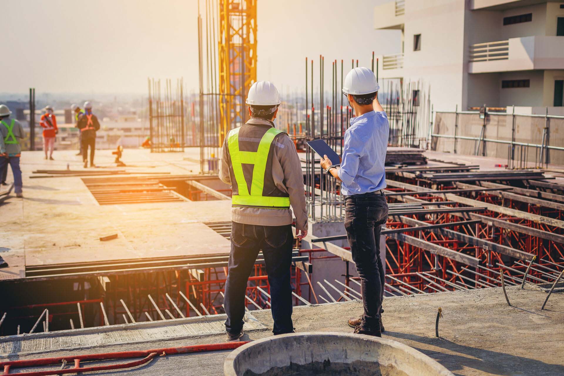 Structural engineer and foreman worker with touch pad discuss, p Construction