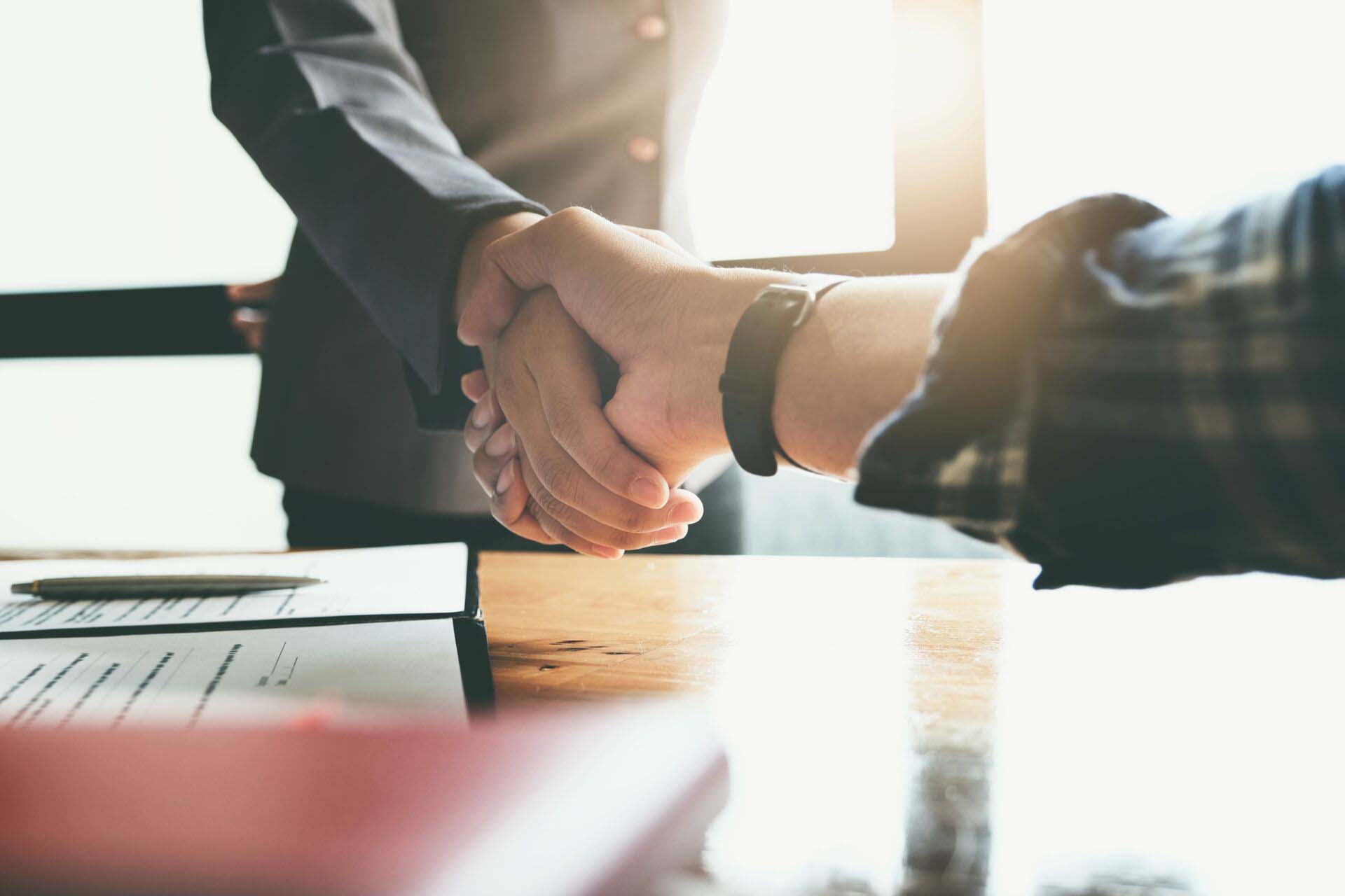 Focus on the congratulatory handshake. The real estate agent agrees to buy the home the customer at the agent’s office. concept agreement. Insurance for Closing Agents