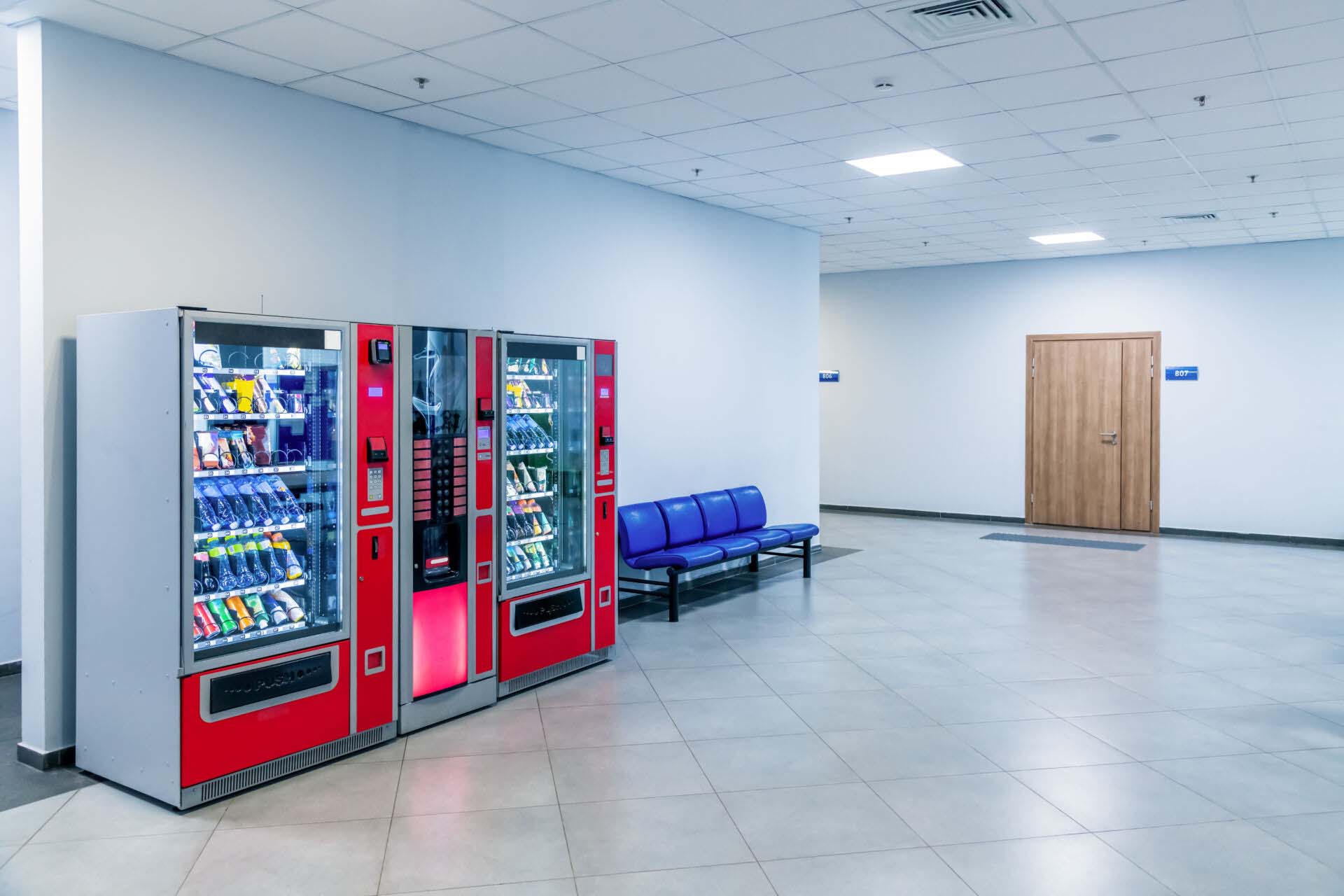 Group of red vending machines stands by the wall. Glare is reflected on a black screen. No people. Copy space for your text. Small business theme. Insurance for Vending Machine Operators