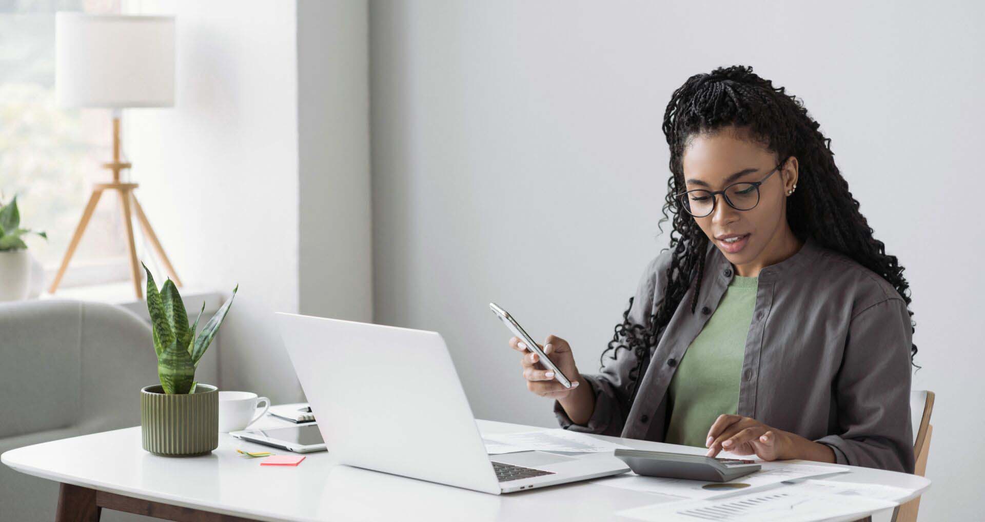 Woman accountant using calculator and computer in office panoram Insurance for Tax Preparers
