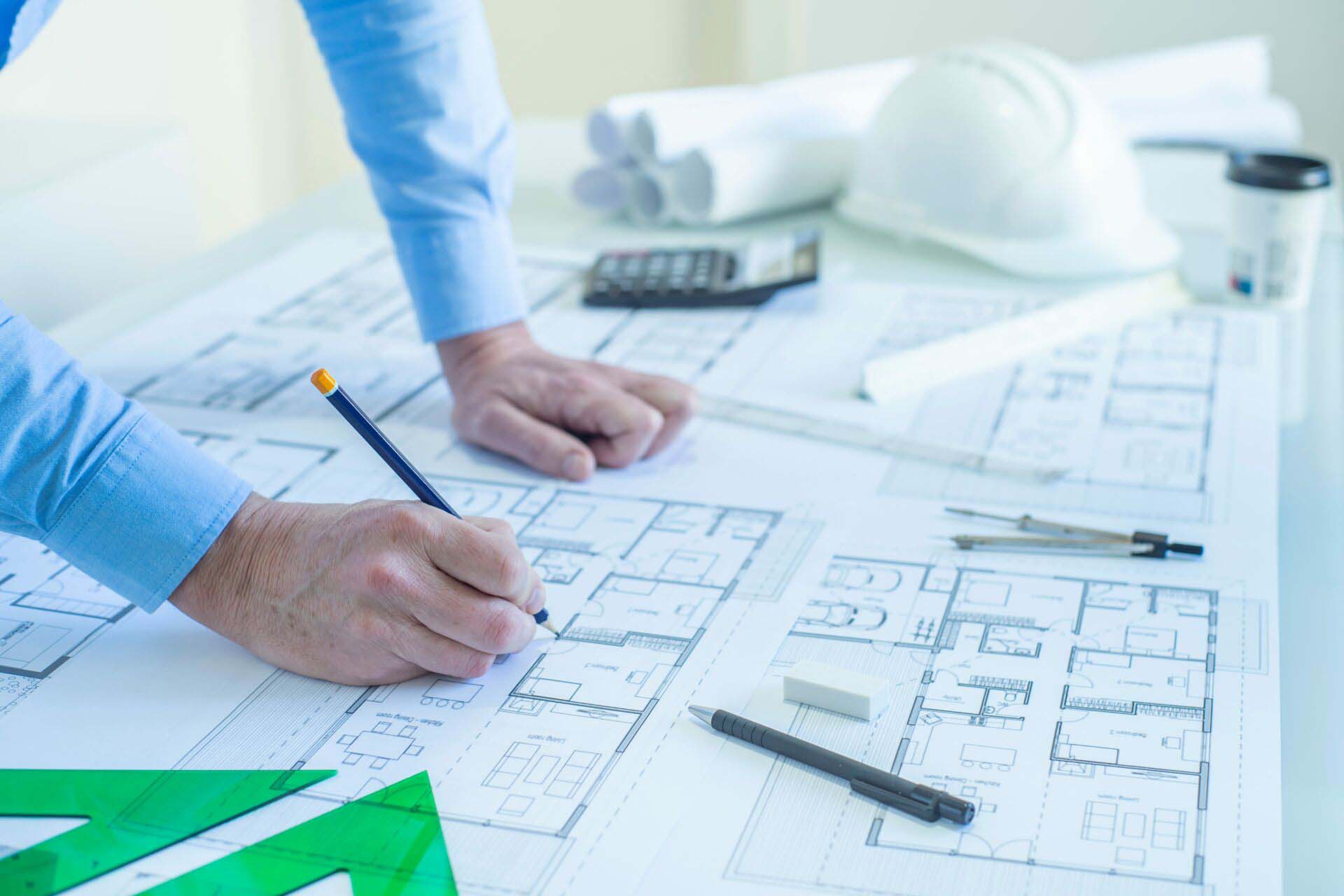 ARCHITECT OR DRAFTSMAN DRAWING PLANS OF THE FLOOR PROJECT OF A HOUSE IN THE STUDIO. SELF EMPLOYED CONCEPT. SELECTED FOCUS. Insurance for Draftsmen