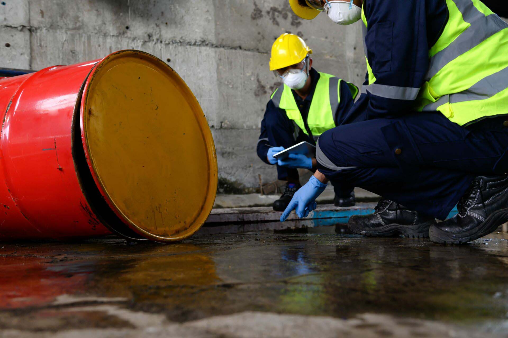 Two Officers of Environmental Engineering wearing masks inspected Oil Spill. Environmental Liability Insurance
