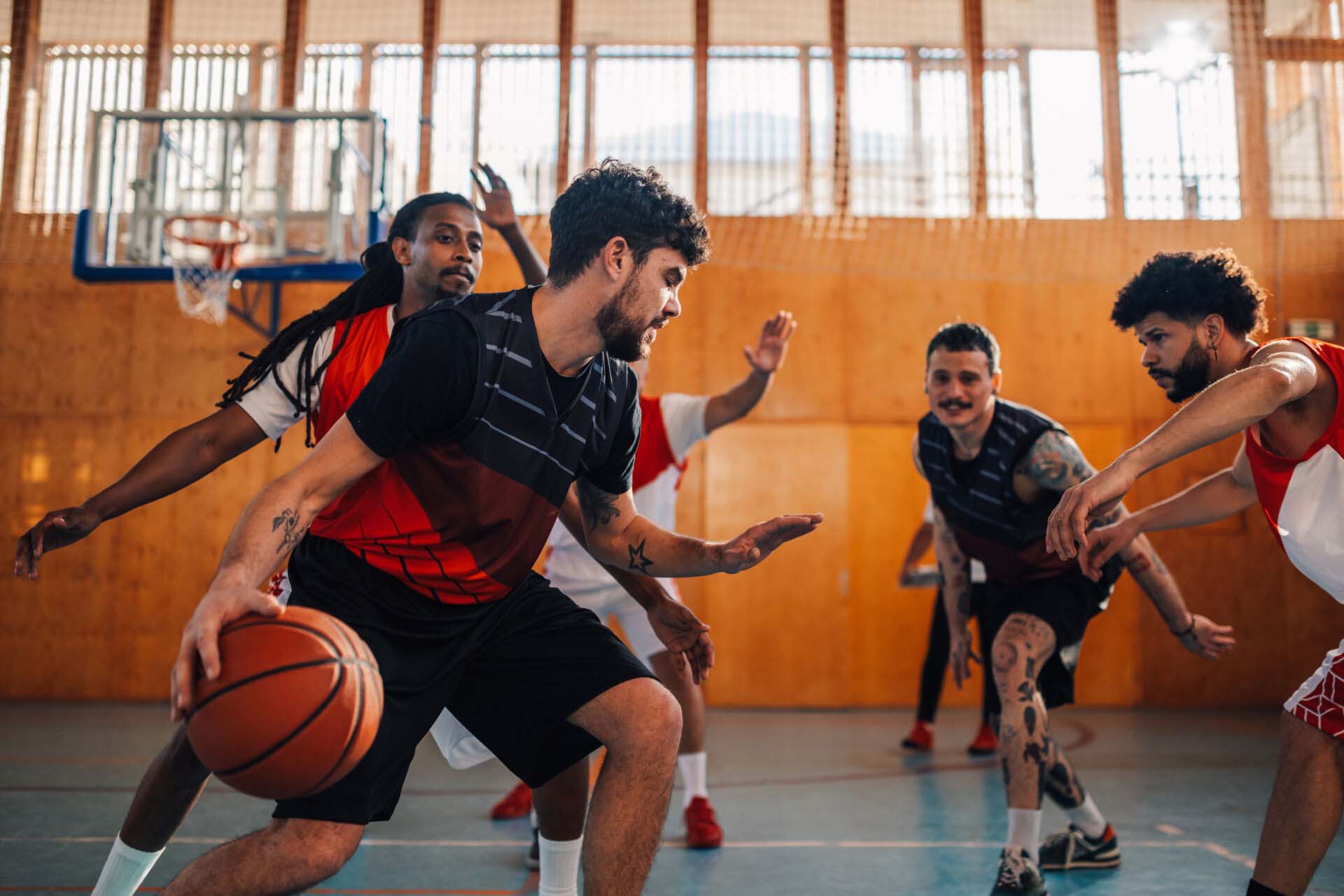 Interracial basketball team is practicing basketball on training. Insurance for Community Centers