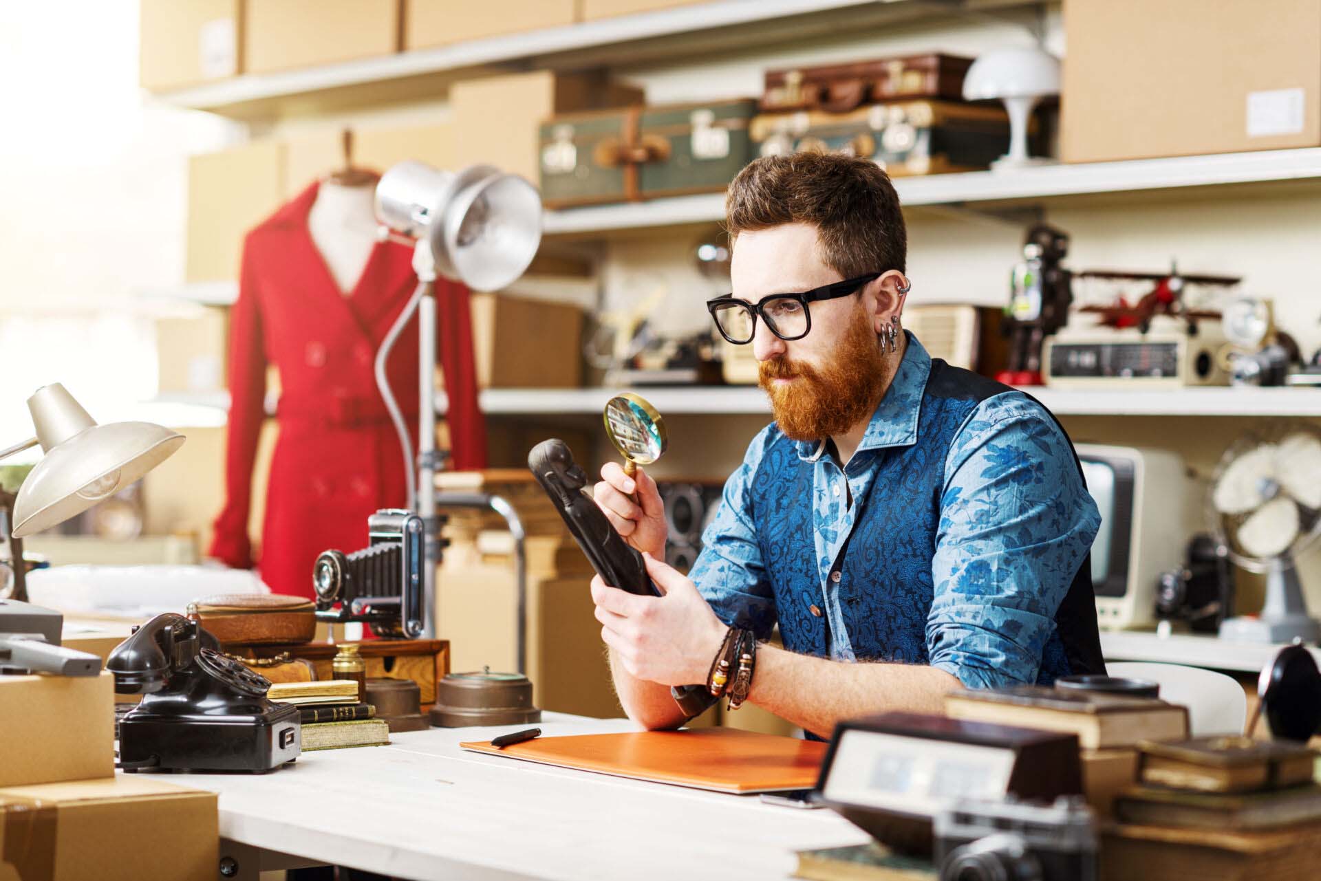 Young business owner checking vintage items in his shop Insurance for Personal Property Appraisers
