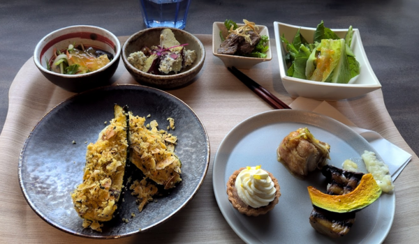 Plates and bowls of food on a wooden table