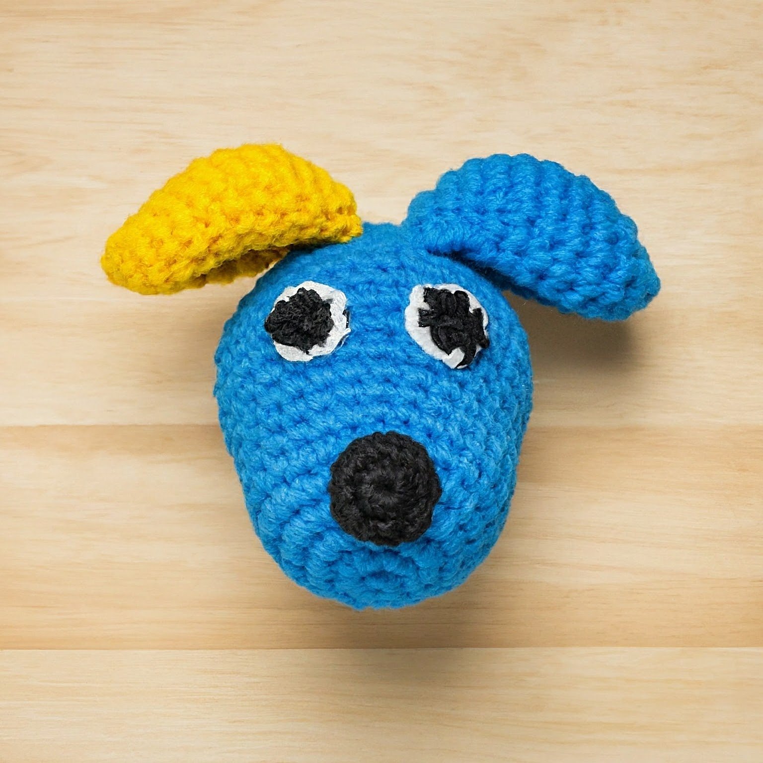 a cute dog made with blue and yellow yarn