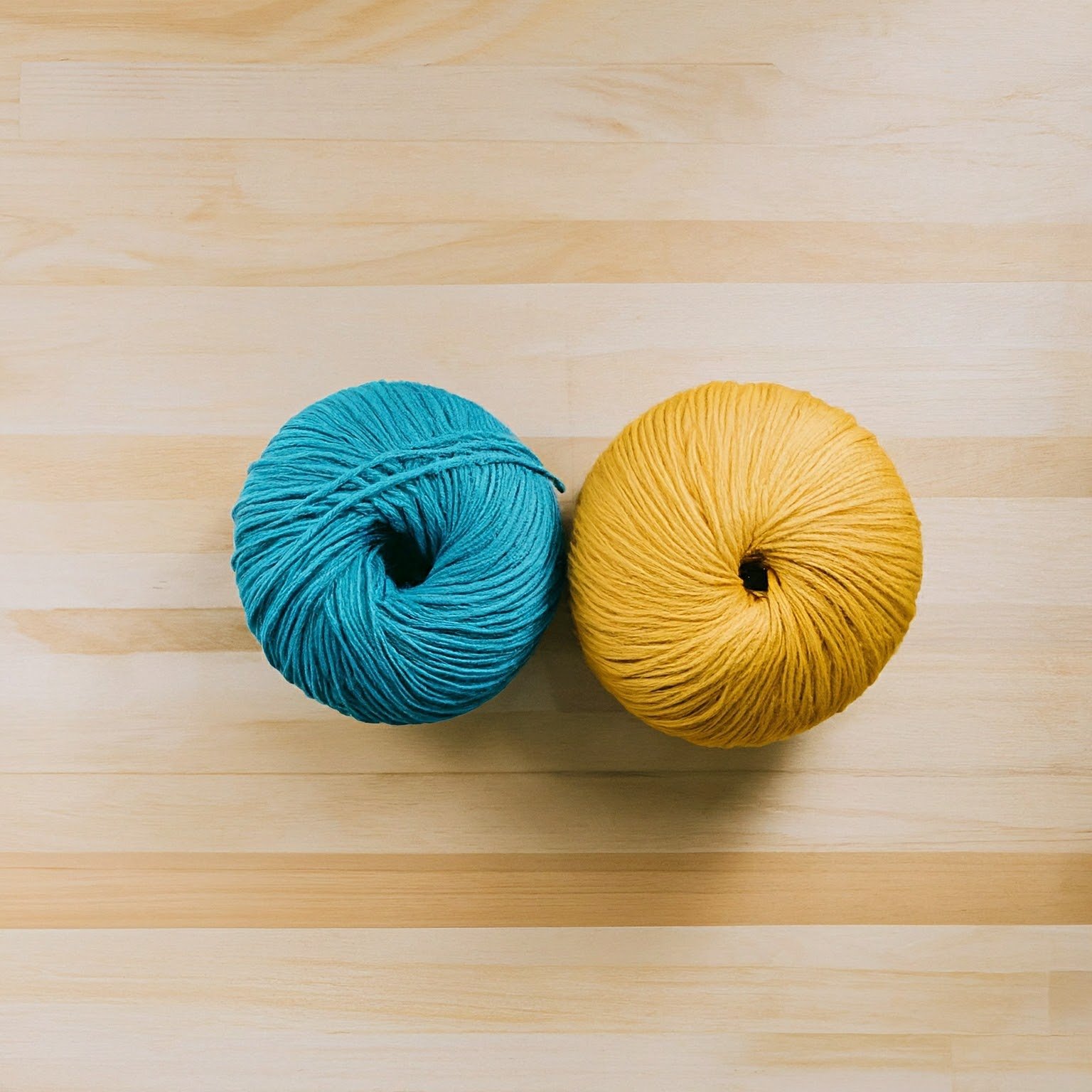 blue ball of yarn next to yellow ball of yarn