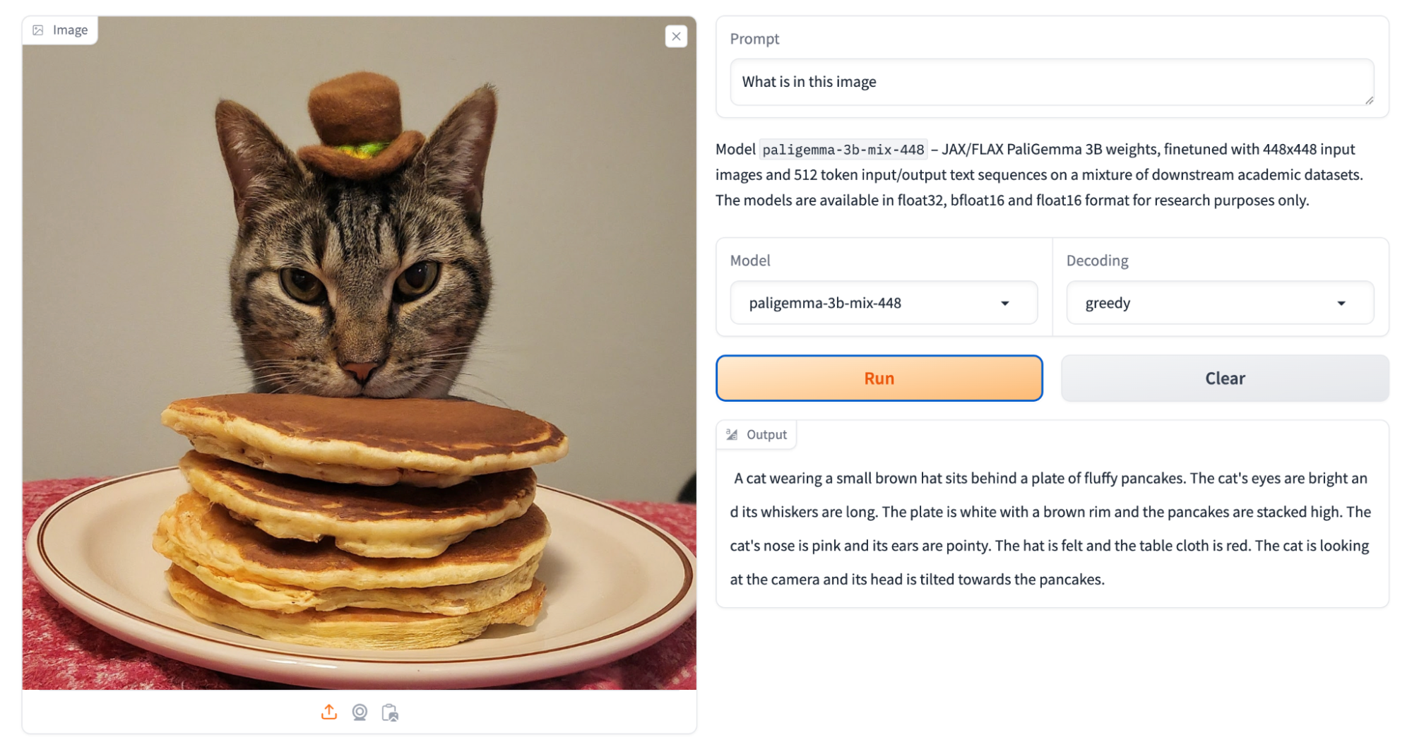 작은 모자를 쓴 고양이의 이미지와 4개의 팬케이크 위에 머리가 올려진 모습을 보여주는 PaliGemma를 실행하는 HuggingFace Space의 스크린샷